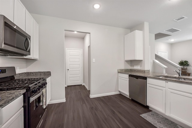 kitchen with visible vents, appliances with stainless steel finishes, dark wood-style floors, and light stone countertops