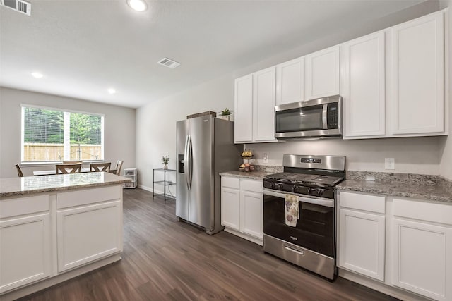 kitchen featuring white cabinets, stainless steel appliances, visible vents, and dark wood-type flooring