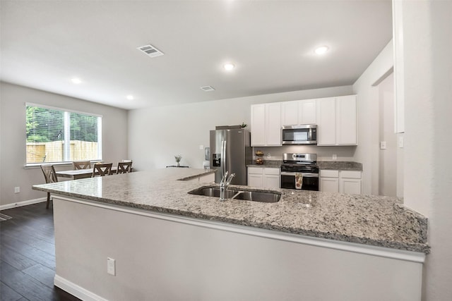 kitchen with visible vents, dark wood-style flooring, white cabinetry, a sink, and appliances with stainless steel finishes