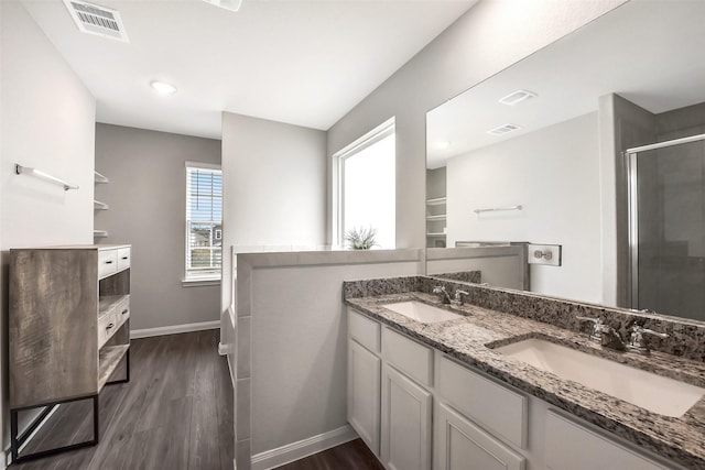 bathroom with visible vents, a shower stall, a sink, and wood finished floors