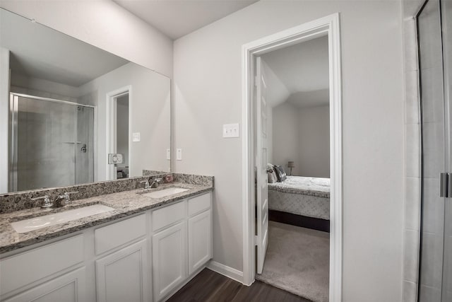bathroom with a sink, a shower stall, ensuite bath, and wood finished floors