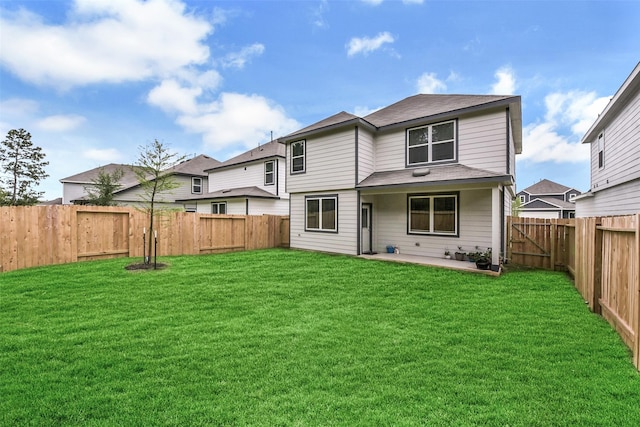 back of house with a lawn, a patio, a fenced backyard, and roof with shingles