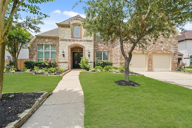 view of front of house featuring brick siding, fence, a front lawn, concrete driveway, and stone siding