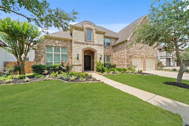 french country home featuring a garage, fence, a front lawn, concrete driveway, and a shingled roof