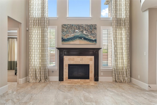 unfurnished living room featuring baseboards and a fireplace