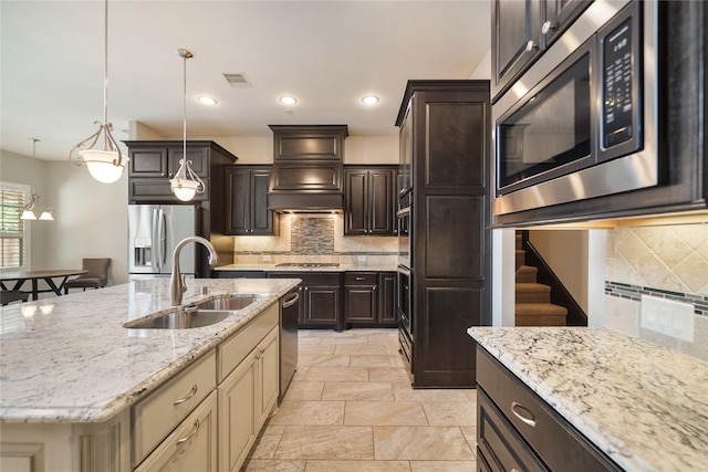 kitchen featuring backsplash, stainless steel appliances, visible vents, and a sink