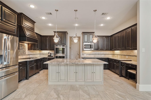 kitchen with stainless steel appliances, visible vents, a center island with sink, and tasteful backsplash