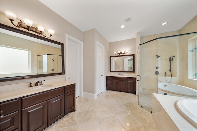 full bath with two vanities, a sink, a garden tub, and a stall shower
