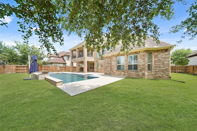 back of property featuring a lawn, a fenced backyard, brick siding, and a patio