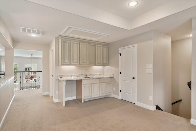 interior space featuring visible vents, a sink, attic access, and light colored carpet