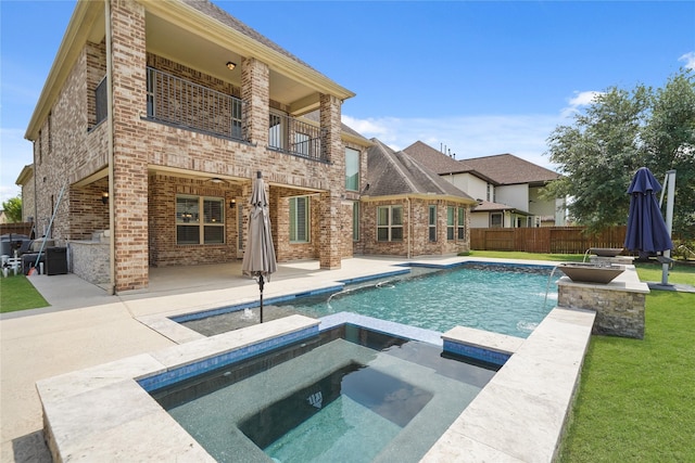 rear view of property featuring a patio area, brick siding, and a balcony