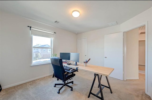 office featuring baseboards, light colored carpet, and visible vents