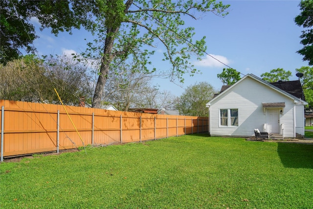 view of yard with a fenced backyard and entry steps