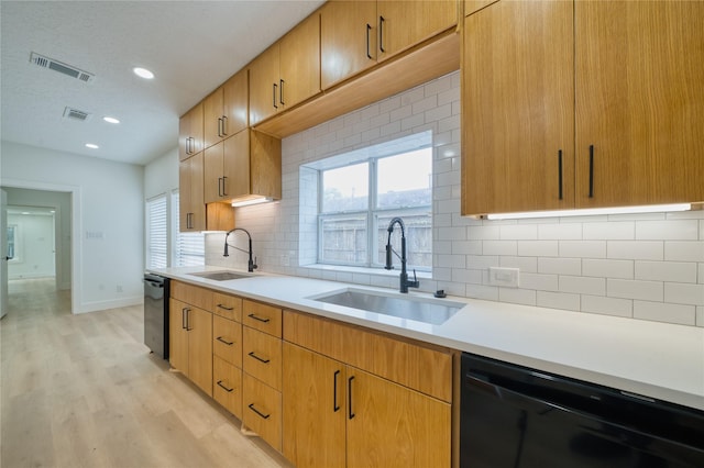 kitchen with a sink, visible vents, and dishwasher