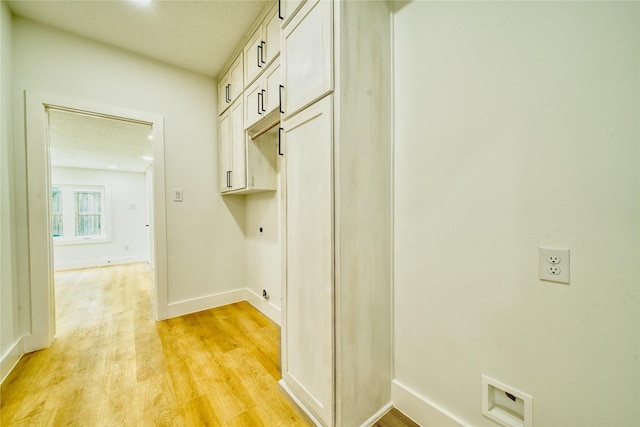 hall featuring baseboards and light wood-style flooring