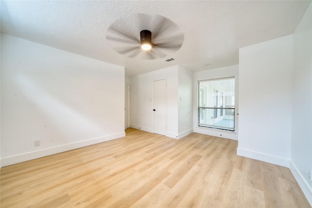 unfurnished bedroom with baseboards, ceiling fan, light wood-type flooring, and visible vents