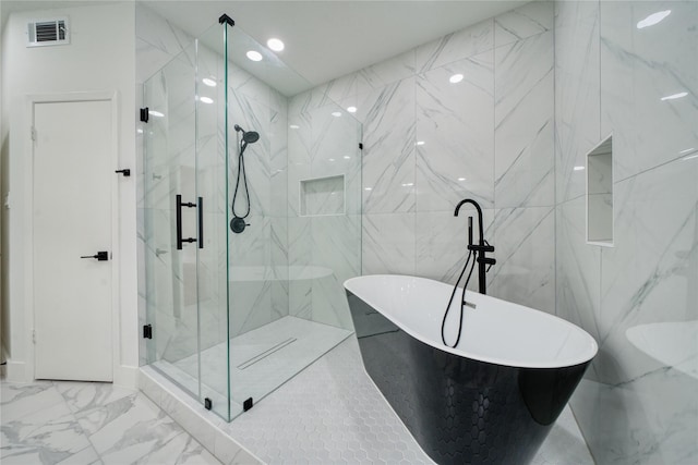 bathroom featuring a freestanding tub, marble finish floor, a marble finish shower, and visible vents
