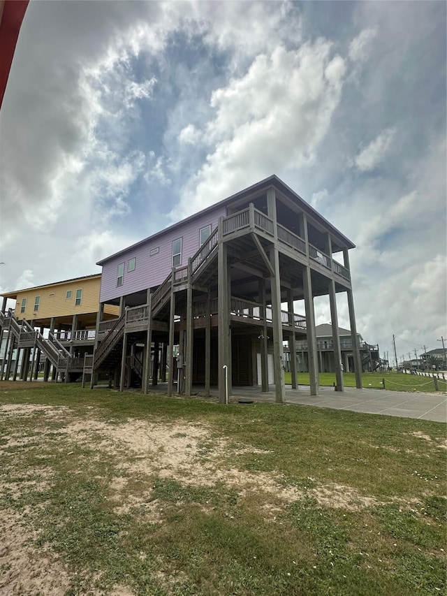 view of property's community featuring a lawn, a deck, and stairway