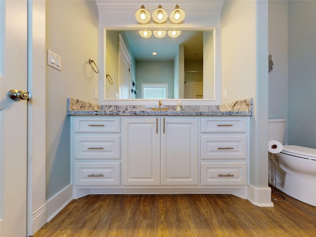 975 S Stingaree, Crystal Beach, TX 77650 - bathroom with toilet, wood finished floors, vanity, and baseboards