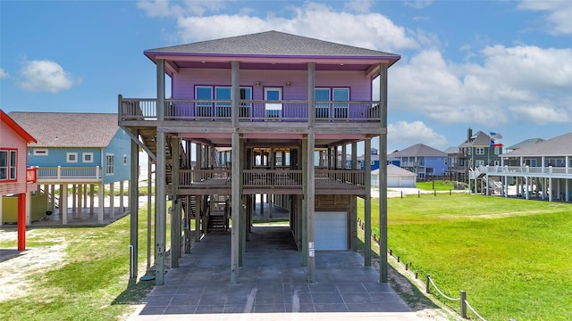 975 S Stingaree, Crystal Beach, TX 77650 - view of front of home featuring an attached garage, stairway, driveway, a front yard, and roof with shingles