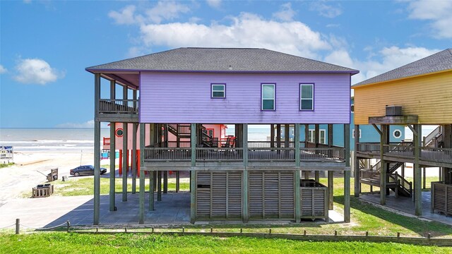 975 S Stingaree, Crystal Beach, TX 77650 - back of property featuring stairs, a patio, a shingled roof, and a water view