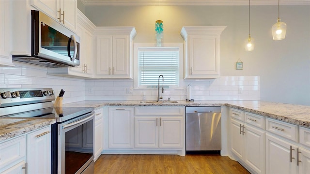 975 S Stingaree, Crystal Beach, TX 77650 - kitchen with stainless steel appliances, a sink, white cabinetry, backsplash, and ornamental molding