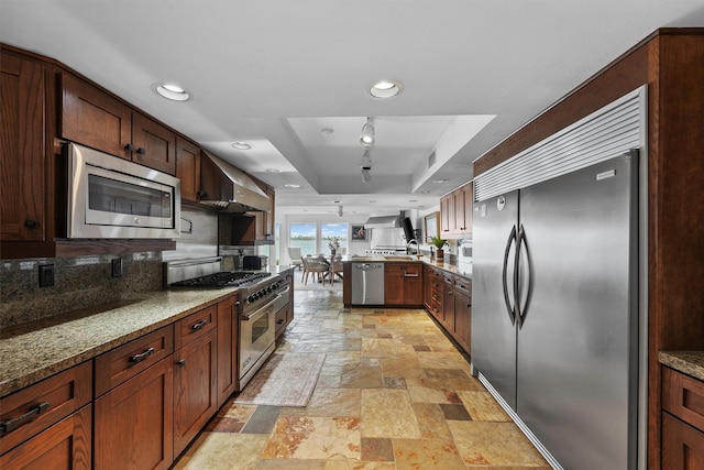 18 S Shore Dr S, Galveston, TX 77551 - kitchen with stone tile flooring, a peninsula, built in appliances, recessed lighting, and a tray ceiling