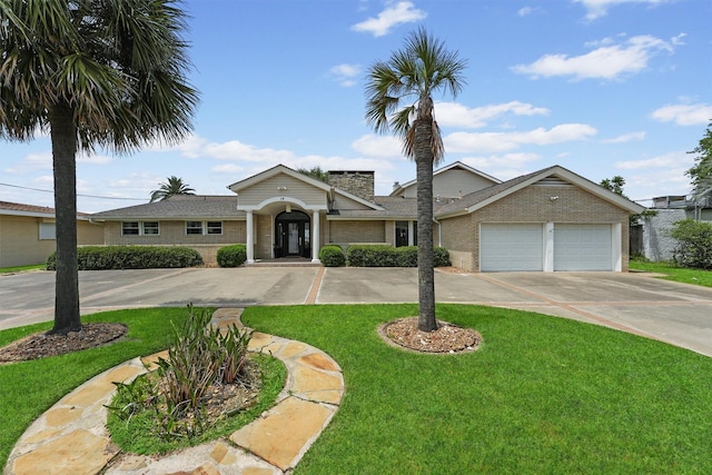 18 S Shore Dr S, Galveston, TX 77551 - ranch-style house with a chimney, an attached garage, concrete driveway, and brick siding