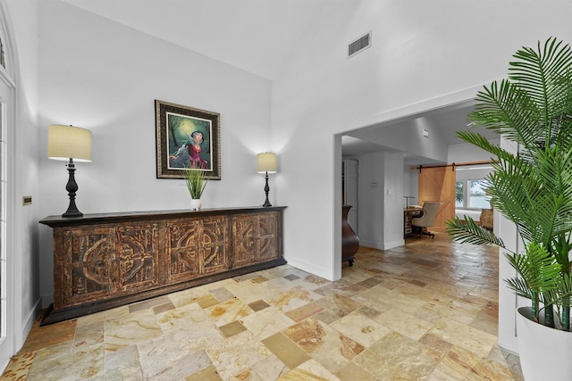 18 S Shore Dr S, Galveston, TX 77551 - corridor with visible vents, stone tile floors, baseboards, and high vaulted ceiling