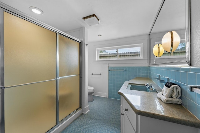 18 S Shore Dr S, Galveston, TX 77551 - full bath with vanity, tile patterned flooring, toilet, tile walls, and a shower stall