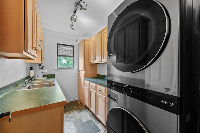 18 S Shore Dr S, Galveston, TX 77551 - clothes washing area with cabinet space, a sink, stone finish floor, baseboards, and stacked washer / dryer