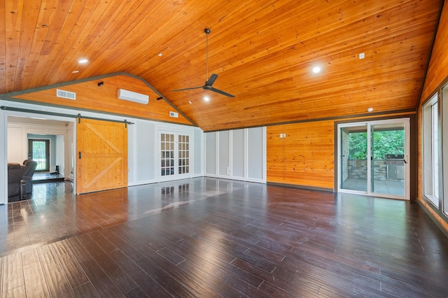 unfurnished living room with vaulted ceiling, wood walls, hardwood / wood-style flooring, a barn door, and wooden ceiling