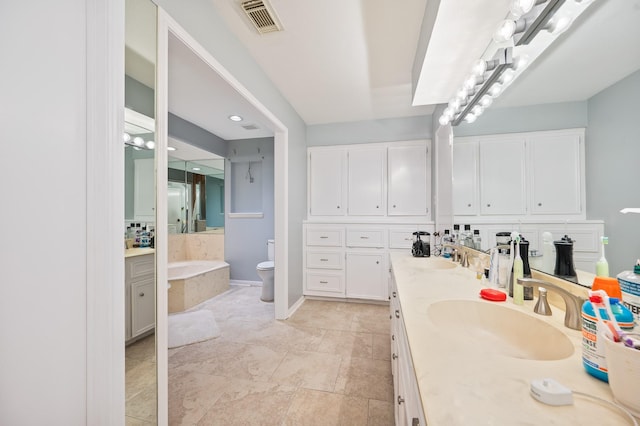 bathroom with visible vents, double vanity, toilet, a bath, and a sink