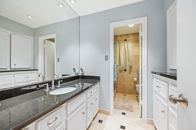 full bath featuring vanity, toilet, baseboards, tiled shower, and tile patterned floors