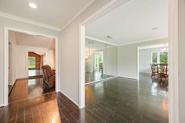 hallway with visible vents, wood-type flooring, and a wealth of natural light