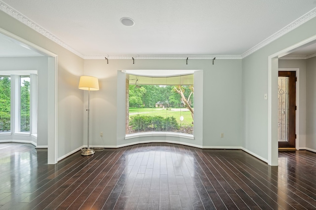 unfurnished room with crown molding, baseboards, and hardwood / wood-style flooring