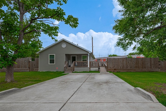 bungalow-style house featuring fence, a gate, and a front lawn