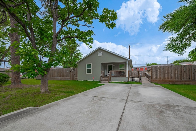 view of front of house featuring fence, a porch, and a front lawn