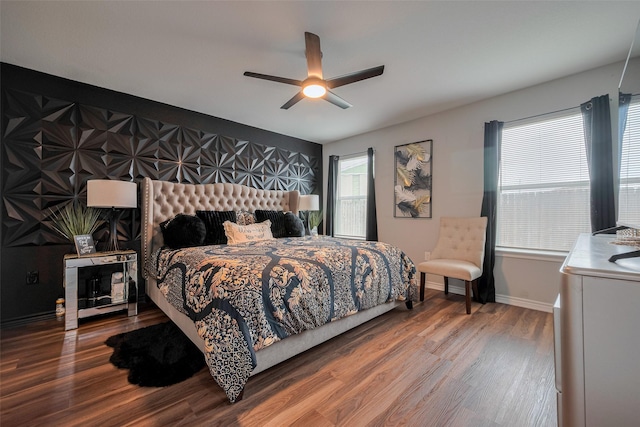 bedroom with a ceiling fan, baseboards, and wood finished floors