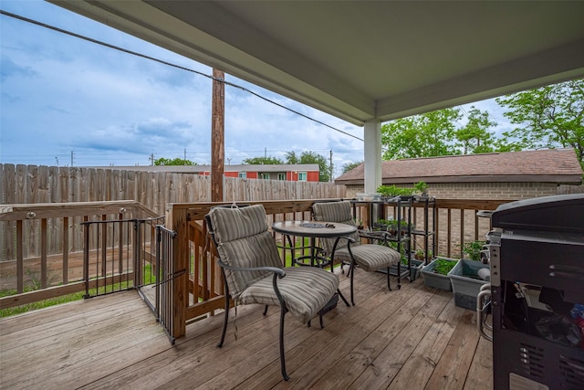 wooden terrace with fence and a grill