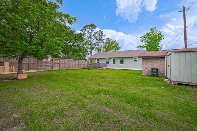 view of yard featuring fence, an outbuilding, and a shed
