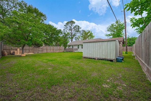 view of yard featuring a fenced backyard, a storage unit, and an outdoor structure