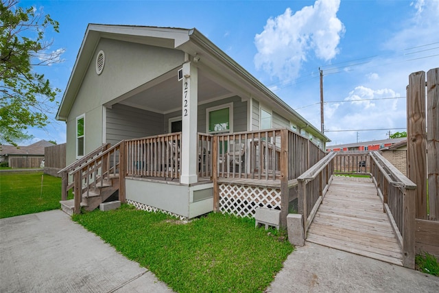exterior space featuring covered porch and a front lawn