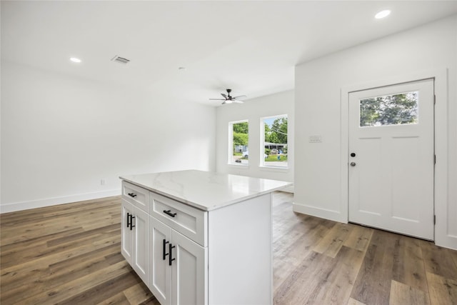 kitchen featuring ceiling fan, light wood finished floors, white cabinetry, a kitchen island, and visible vents