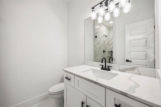 full bath featuring baseboards, a marble finish shower, toilet, and vanity