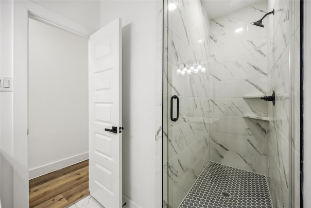 full bathroom featuring a marble finish shower and baseboards