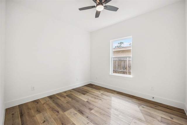 spare room featuring baseboards, ceiling fan, and wood finished floors