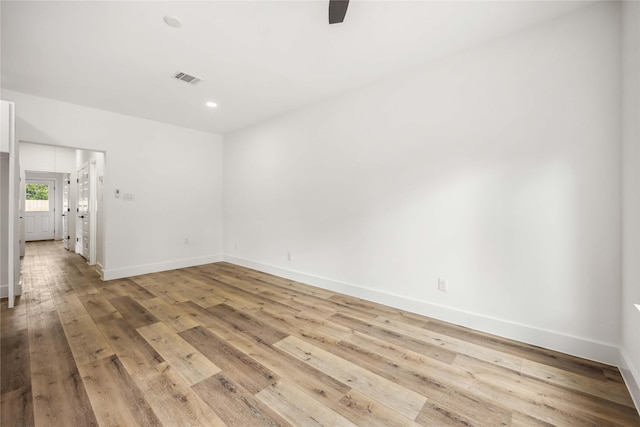 spare room with ceiling fan, baseboards, visible vents, and light wood-style flooring