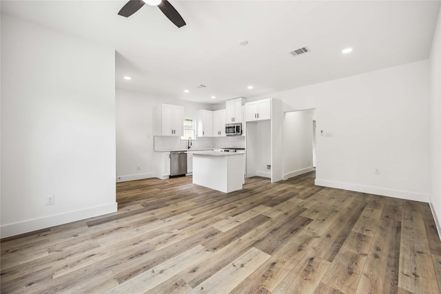 unfurnished living room with visible vents, light wood-style floors, ceiling fan, recessed lighting, and a sink
