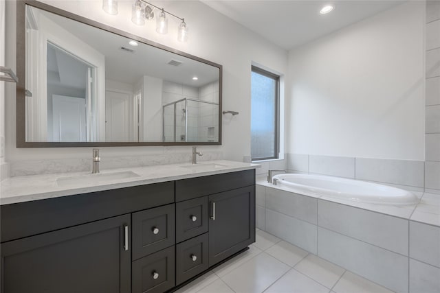 12810 Belford Gardens Dr, Humble, TX 77346 - bathroom with a shower stall, a bath, double vanity, tile patterned flooring, and recessed lighting